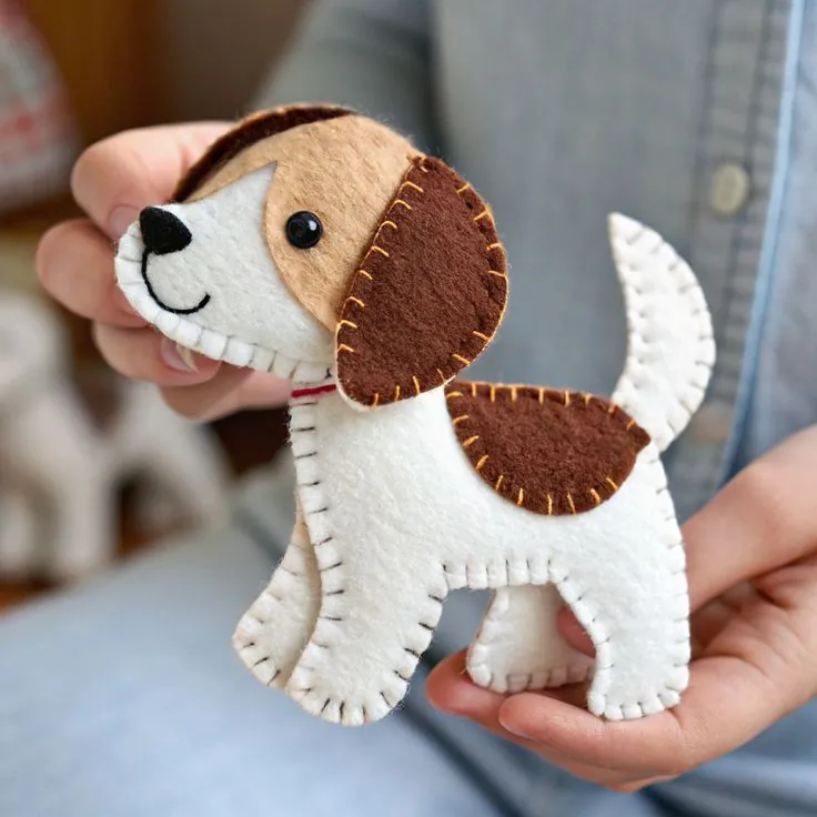 Finished felt beagle in white, beige and brown with a floppy ear and orange blanket stitching, sewn from KoraLoveDesigns Volume 3