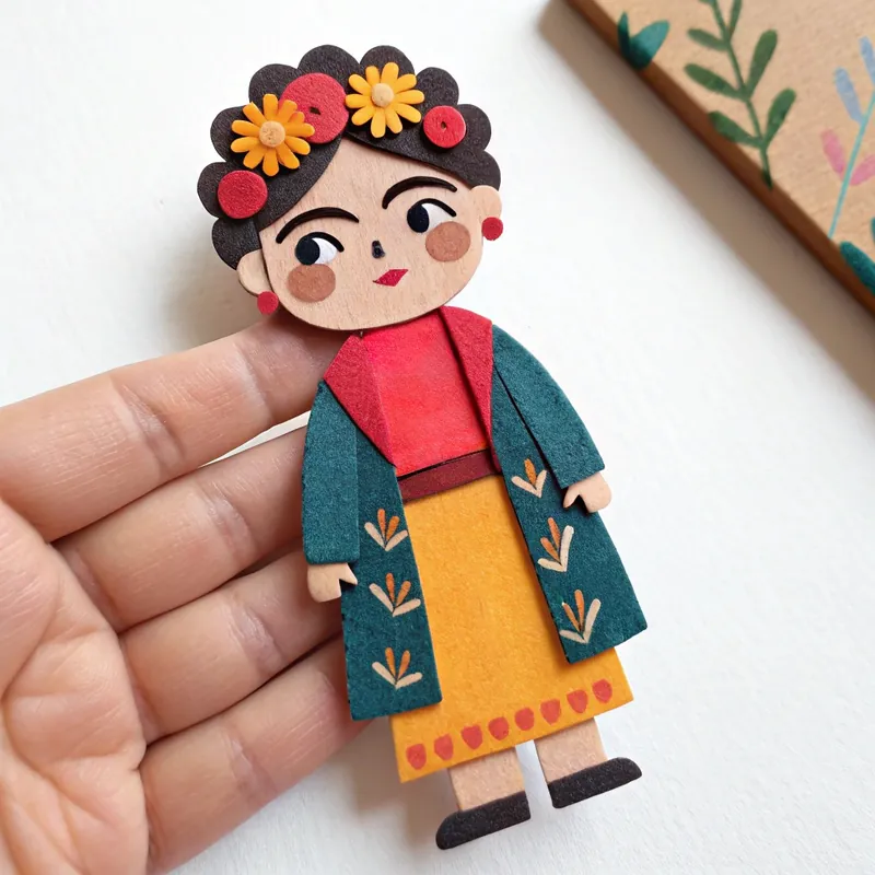 Finished felt doll inspired by Frida Kahlo with a flower crown, green coat and yellow skirt